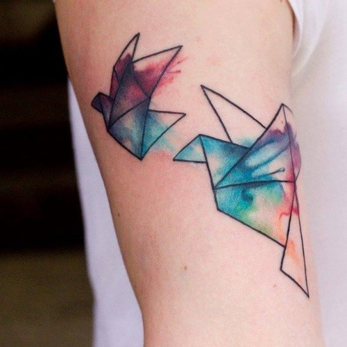 Tatuaggio colorato sul braccio i disegni in forma degli uccelli