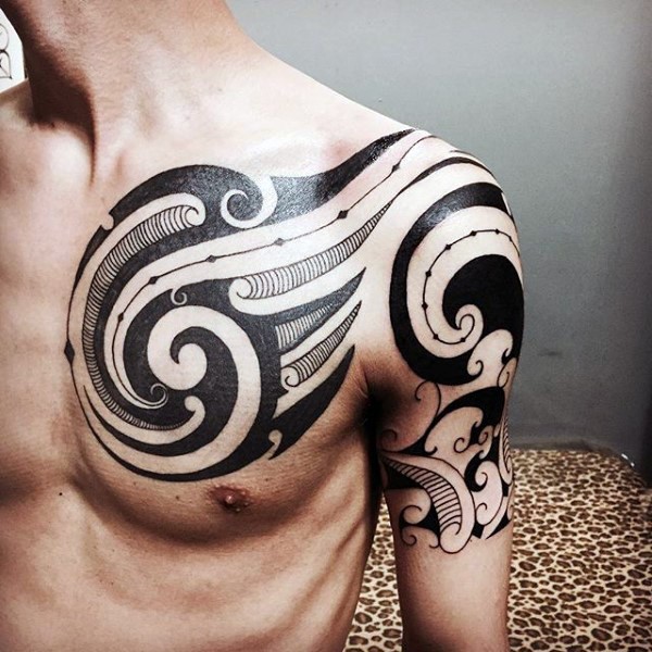 Original black and white tribal ornaments tattoo on chest and shoulder