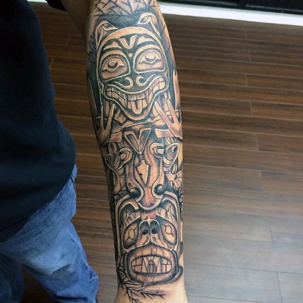 Original black and white tribal statue tattoo on arm