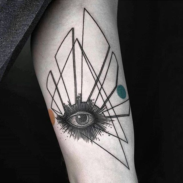 Original black ink human eye tattoo on forearm with big geometrical figures and colored circles