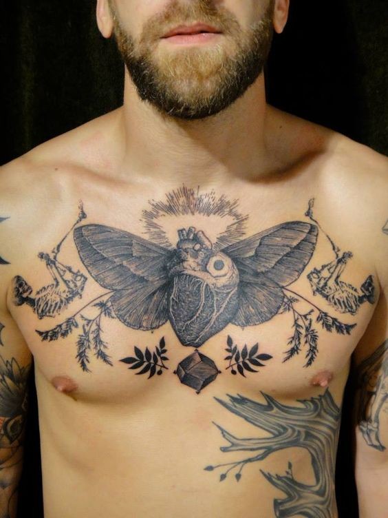 Original black ink human heart with wings tattoo on chest combined with leaves and skeletons