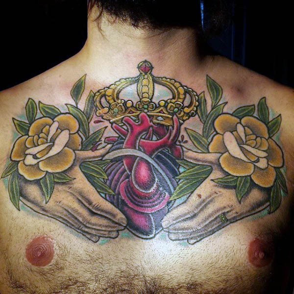 Original colored big chest tattoo of human heart with hands and crown