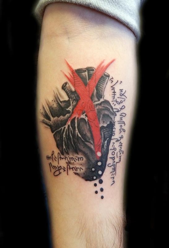 Tatuaje en el antebrazo, corazón humano negro con rayas rojas y inscripciones