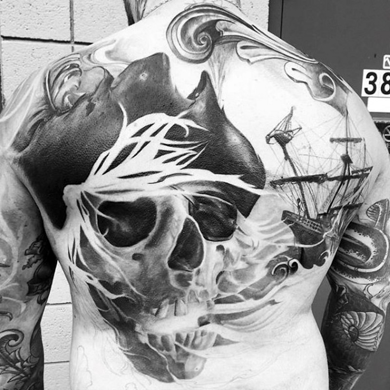 Tatuaje en la espalda, cráneo de pirata espantoso y barco detallado