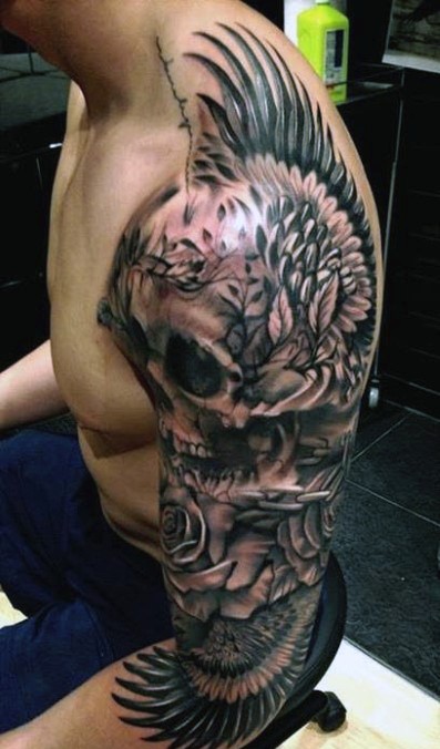 Tatuaje en el brazo,
cráneo grande con rosas y alas, dibujo negro blanco detallado