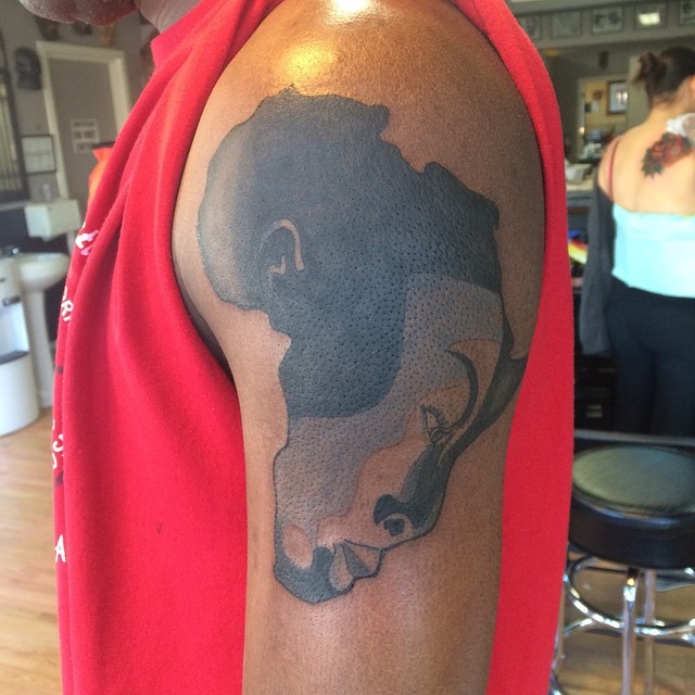 Original combined black ink shoulder tattoo of Africa continent with tribal human face