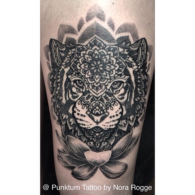 Tatuaje original en tinta negra combinada de cabeza de tigre estilizada con varias flores