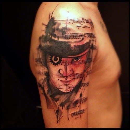 Original combined colorful man portrait tattoo on shoulder stylized with music notes