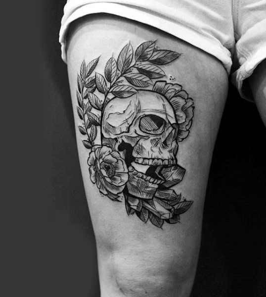 Original designed black and white skull tattoo on thigh stylized with flowers and feather