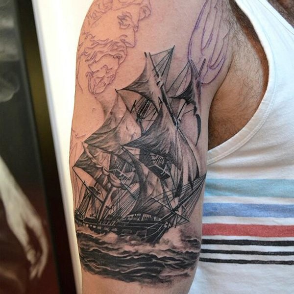 Original looking colored shoulder tattoo of sailing ship in waters