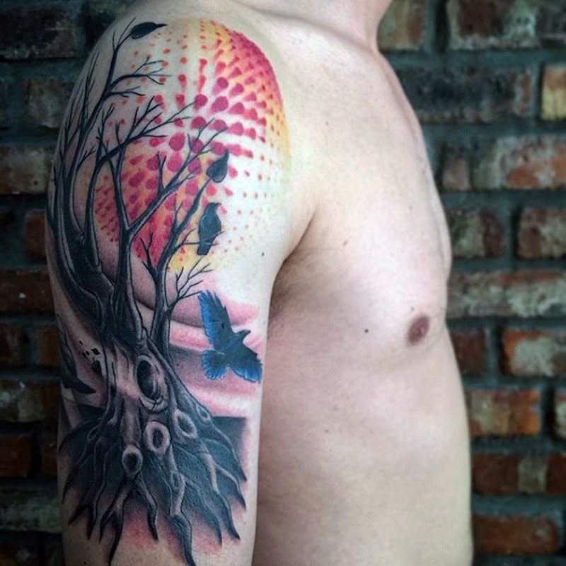 Tatuaje en el brazo, árbol muerto con aves y sol divino