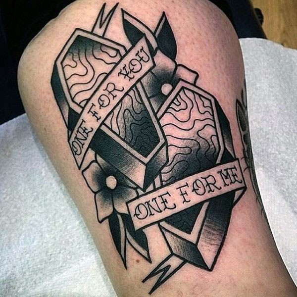 Tatuaje en el brazo, dos ataúdes y cintas con inscripciones, colores negro y blanco