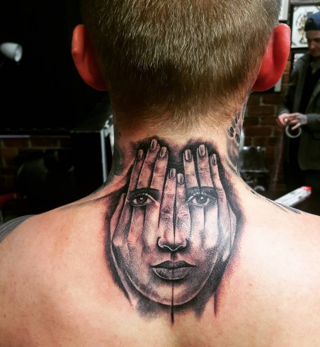 Original painted black ink hands with face tattoo on upper back