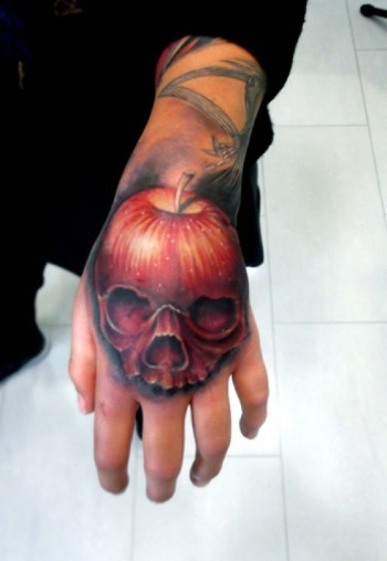 Tatuaje en la mano, 
manzana roja 3D en forma de cráneo