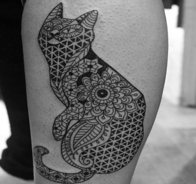Ornamental style black ink leg tattoo of cat stylized with various ornaments