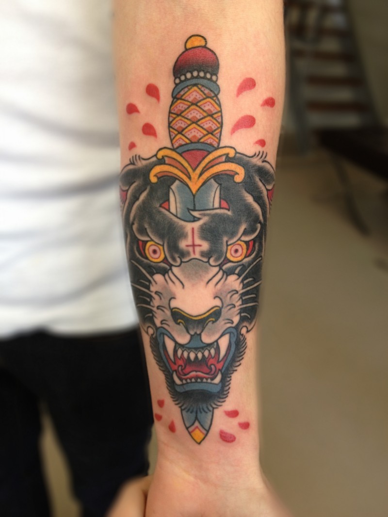 Tatuaje en el brazo de la cabeza de una pantera con una daga.