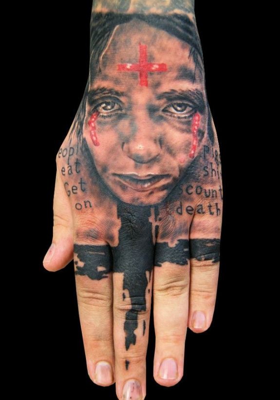 Photoshop style colored hand tattoo of woman face with red cross and lettering