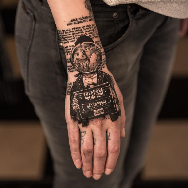 Photoshop style colored wrist tattoo of police like portrait and lettering