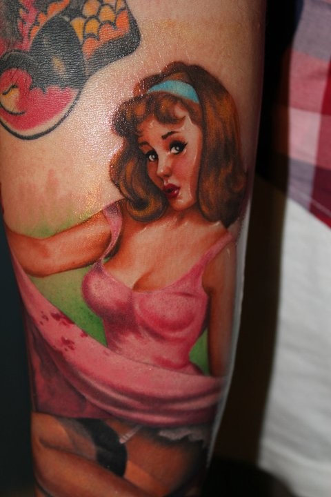 Pinup girl in a pink dress tattoo by Riccardo Cassese