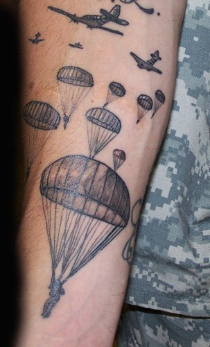 Tatuaje en el brazo de aeroplanos y paracaidistas.