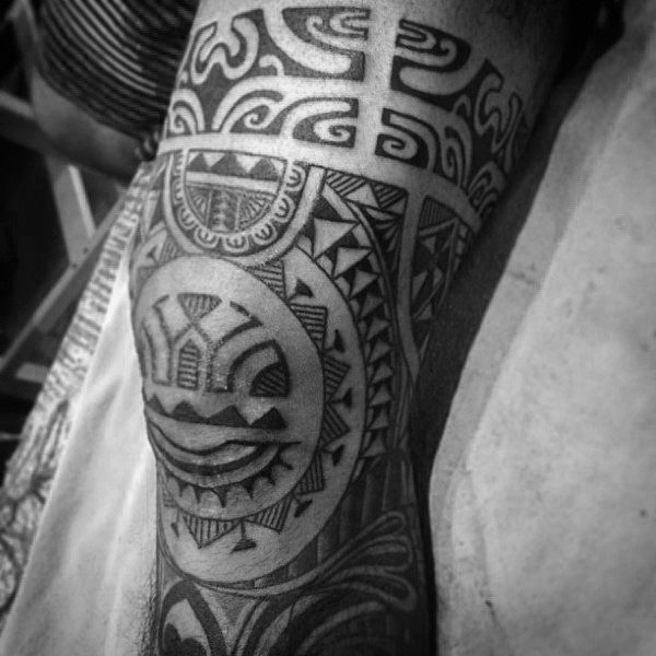 Polynesian style black ink leg tattoo of various ornaments