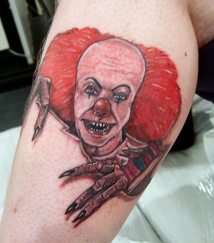 Portrait of a terrible red haired clown skin rip tattoo