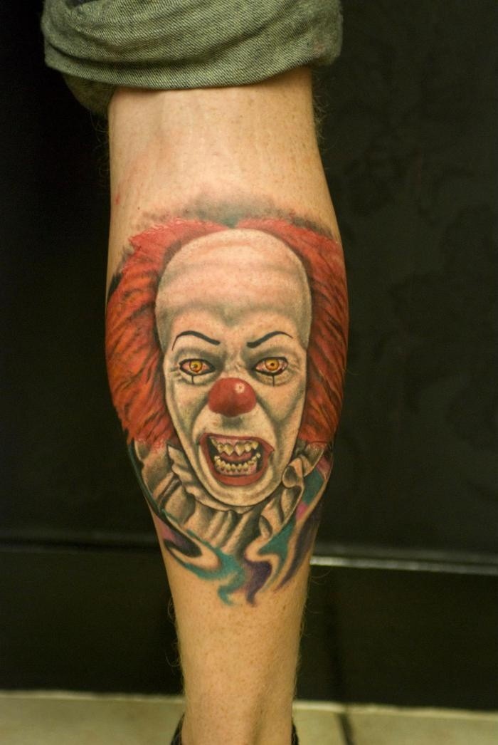 Porträt eines schrecklichen rothaarigen Clowns Tattoo am Bein