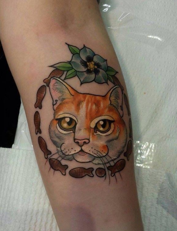 Tatuaje en el antebrazo, gato en el marco de peces