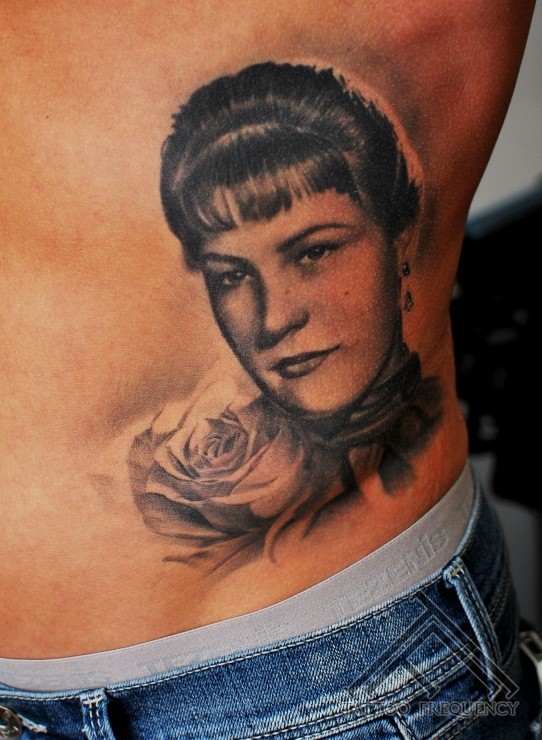 Portrait style black and white side tattoo of woman portrait and rose
