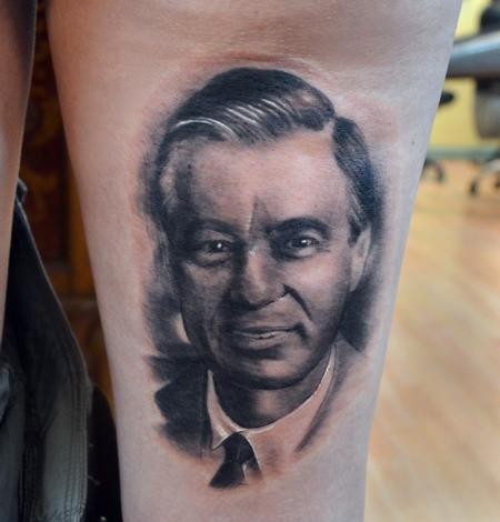 Portrait style black and white thigh tattoo of vintage man face
