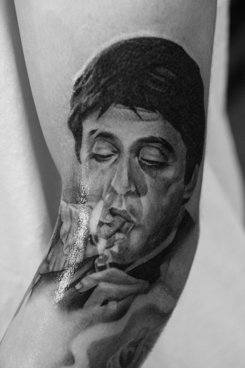 Portrait style colored arm tattoo of smoking mafioso