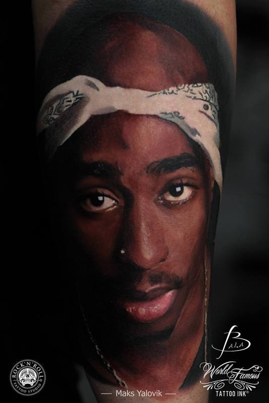 Portrait style colored arm tattoo of 2PAC face