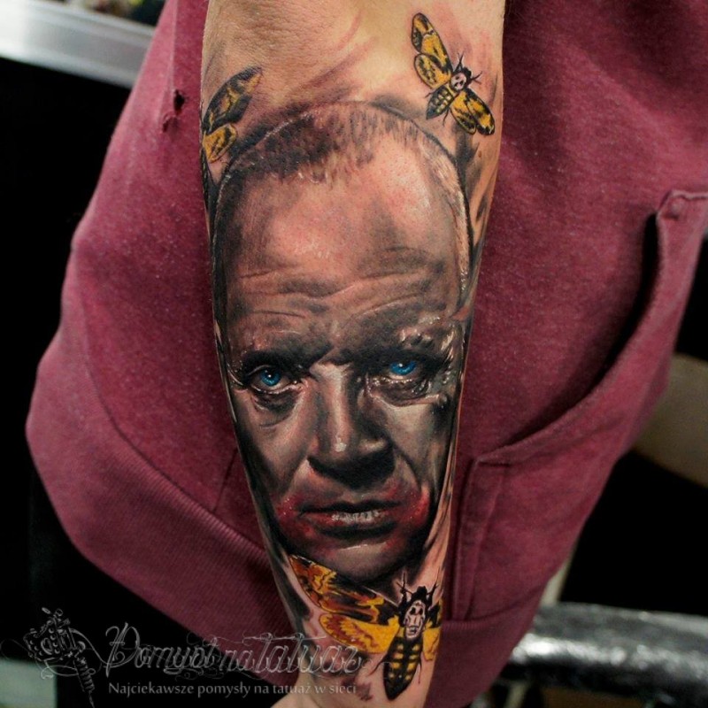 Portrait style colored arm tattoo of of creepy Hannibal