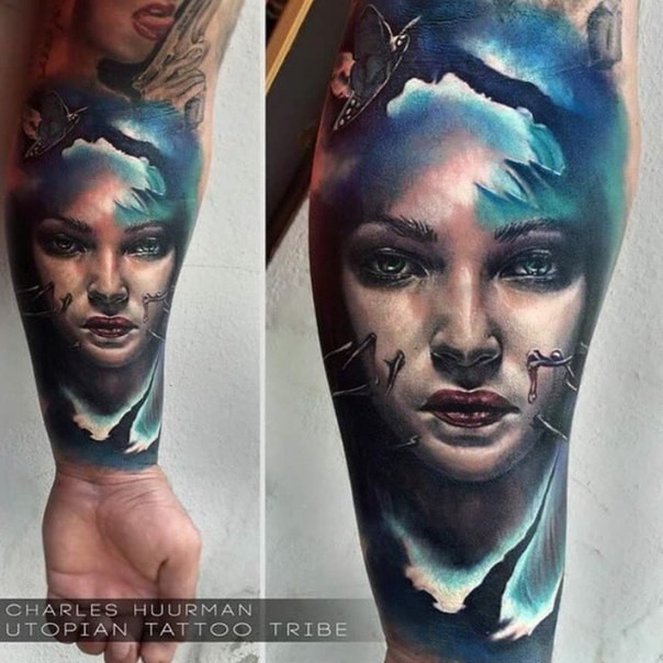 Portrait style colored forearm tattoo of woman face
