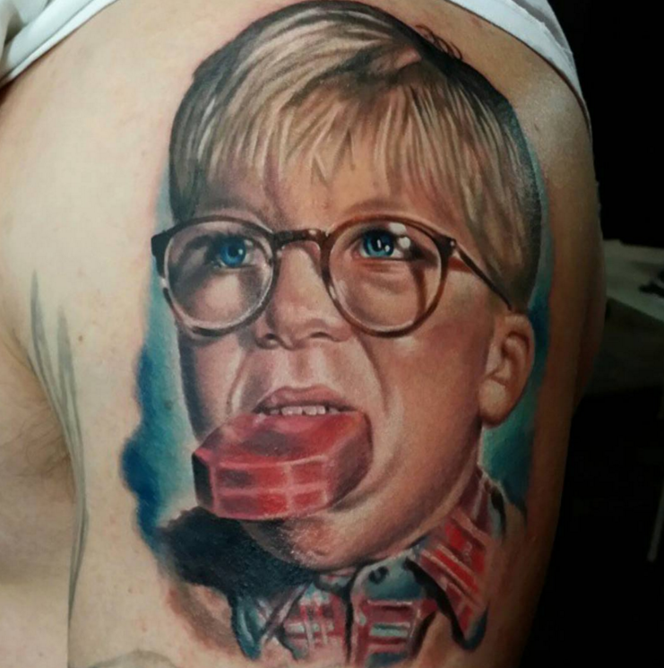 Portrait style colored shoulder tattoo of boy eating red cookie