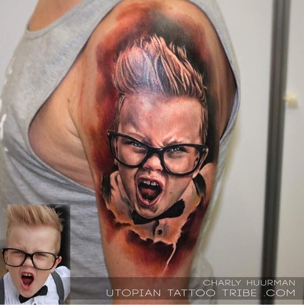 Portrait style colored shoulder tattoo of little boy in glasses