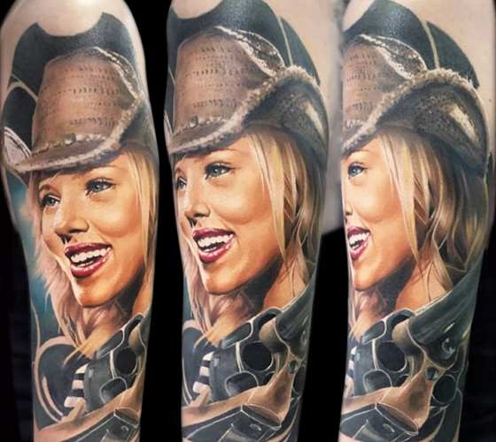 Portrait style colored shoulder tattoo of cowboy woman with revolver