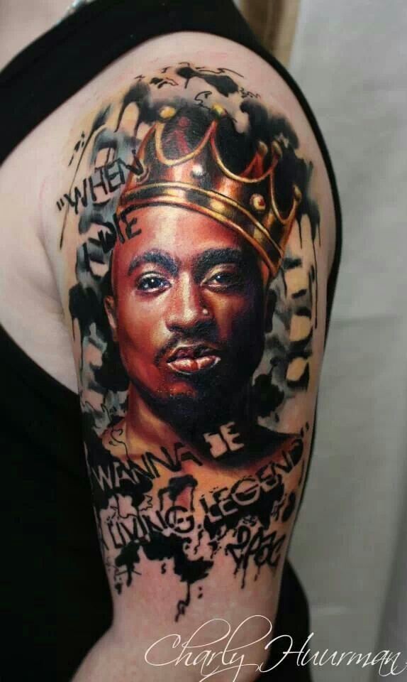 Portrait style colored shoulder tattoo of 2PAC with crown and lettering