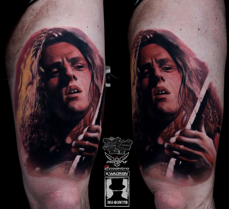 Portrait style colored thigh tattoo of famous guitar player