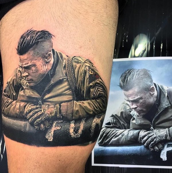 Portrait style colored thigh tattoo of Brad Pitt hero from Fury movie