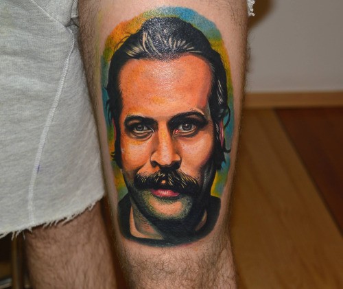 Portrait style colored thigh tattoo of of man with mustache