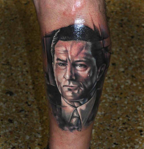 Portrait style colored very detailed leg tattoo of man in suit portrait