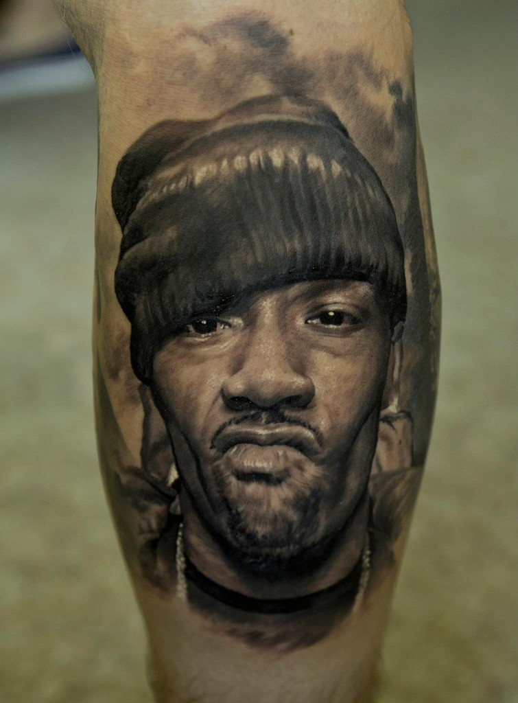 Portrait style realistic looking tattoo of thigh man face