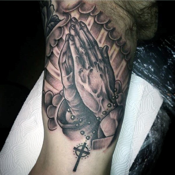 Praying hands with cross on chain memorial tattoo on biceps