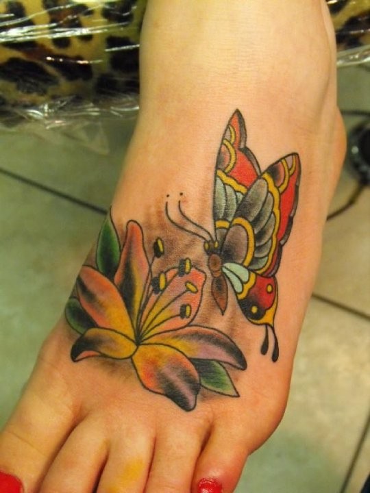 Tatuaje en el pie,
mariposa con lirio, diseño abigarrado