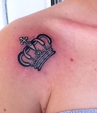 Tatuaje en el hombro, corona negra pequeña