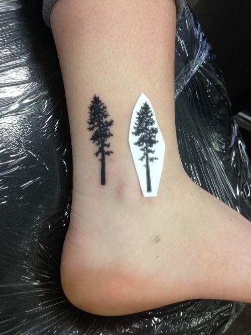 albero solitario piccolo nero su caviglia tatuaggio