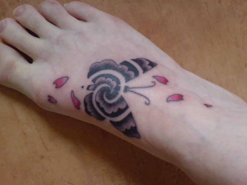 Tatuaje en el pie,
mariposa gris con pétalos rosados