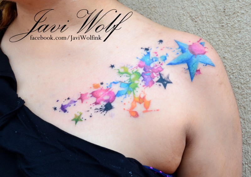 Rainbow colored stars with paint drips tattoo on chest and shoulder by Javi Wolf in watercolor style