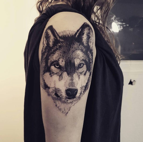 Real life like detailed upper arm tattoo of wolf portrait